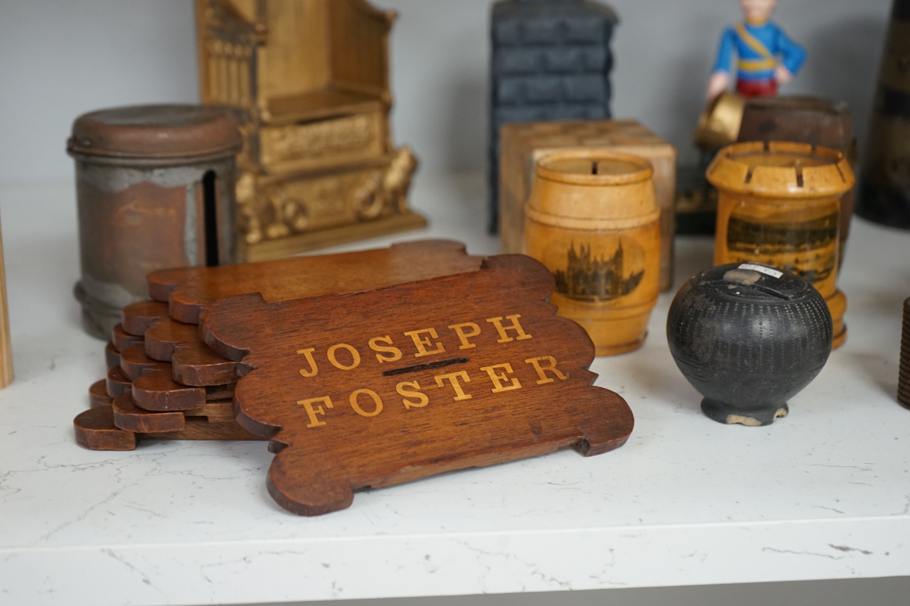 A collection of mixed tin wood and ceramic money boxes to include Cadbury’s milk chocolate, three in the form of trunks and a ceramic pig. Condition - varies